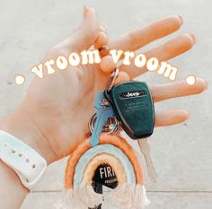 a hand holding a car key with the words vroom vroom on it