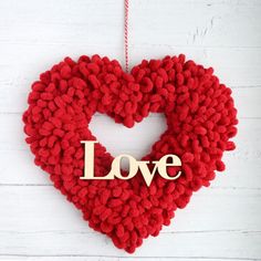 a knitted heart shaped ornament with the word love hanging from it's side