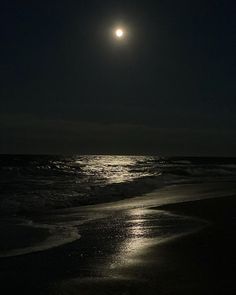 the moon is shining over the ocean on a dark night with no one in sight