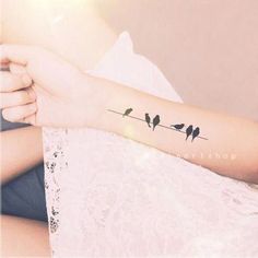 a woman's arm with birds on it and the words love is in her hand