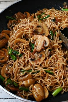 noodles with mushrooms and green onions in a skillet