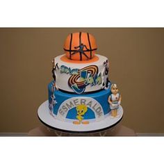 a three tiered cake decorated with basketballs and other sports related items on it