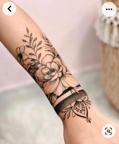 a woman's arm with a flower tattoo on it and an arrow in the middle