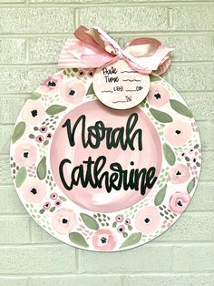 a pink and green plate with the words noah caterine painted on it's side