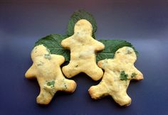 three cookies shaped like people with green leaves