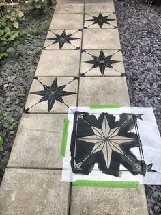 some black and white tiles on the ground with green trimmings in front of them