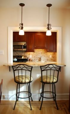 two bar stools sit at the end of a kitchen island