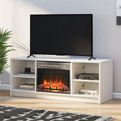 a flat screen tv sitting on top of a white entertainment center next to a fireplace