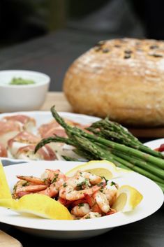 a plate with asparagus and shrimp on it next to other plates of food