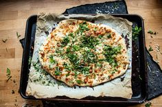 a pizza sitting on top of a pan covered in cheese and toppings next to a knife