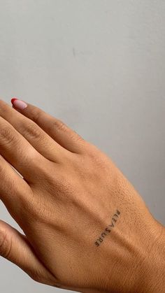 a woman's hand with a small tattoo on it