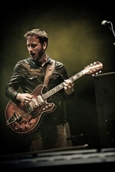 a man playing an electric guitar on stage