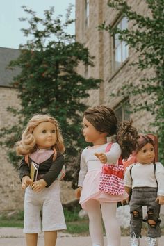 three dolls standing next to each other in front of a building