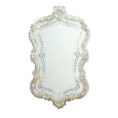 a white and gold framed mirror with beaded trimmings on the edges,