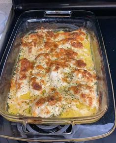 a casserole dish with chicken and cheese in it sitting on the stove top