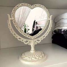 a mirror that is sitting on top of a shelf in front of a white bed