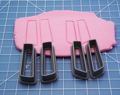 three cookie cutters sitting on top of a cutting mat