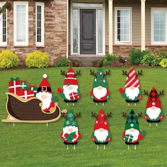 christmas yard decorations in front of a house with santa clause and reindeer on the lawn