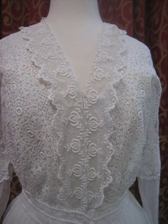 "1914, 36\" bust , elaborate cotton lace on net, wedding dress. dress has lace edged net apron, beneath belt, around hips. Bodice is entirely worked in lace, and has a narrow lace ruffle edged alone V shaped neckline. Sleeves are long with lace cuffs, with a net middle, and a lace band around the upper arm. The gown is fastened in front with hooks and eyes from bodice to waist, and snaps from waist to thigh. Measurements: bust 36\" waist 26\" shoulder to shoulder 17\" sleeves 21\" arm holes 9\" Net Wedding Dress, Lace Bands, Lace Cuffs, Lace Ruffle, Lace Edging, Ladies Fashion, Cotton Lace, V Shape, Apron