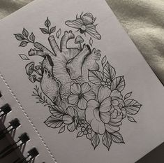 a drawing of a heart surrounded by flowers on a sheet of white paper with black ink