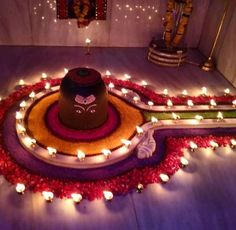 a large hat sitting on top of a floor surrounded by candles and flowers with lights around it