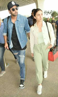 a man and woman walking through an airport