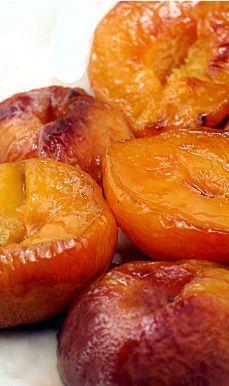 sliced peaches sitting on top of a white plate next to another fruit type item