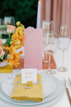 a table set with place cards, napkins and wine glasses