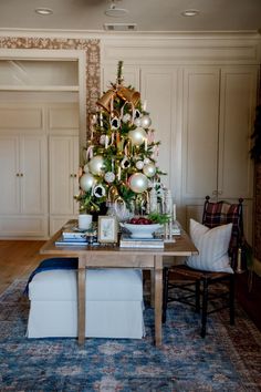 a living room with a christmas tree in the center and other decorations on the table