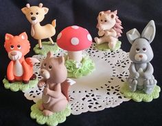 small figurines of various animals on a doily with a mushroom in the middle