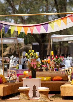 an outdoor event with colorful flags and seating for people to sit down at the table