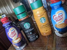 four starbucks coffee drinks lined up on a counter