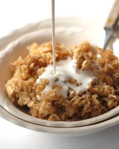 a bowl filled with oatmeal and milk being drizzled over it