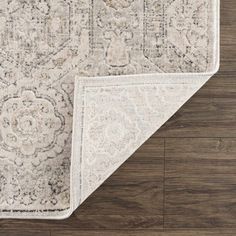 the area rug is laid on top of a wooden floor and has an ornate design