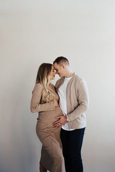 a pregnant woman and man standing next to each other