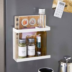 two shelves holding spices and condiments on the wall next to a coffee pot