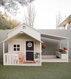 a small white house with a porch and deck