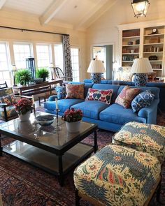 a living room filled with blue couches and lots of pillows on top of them