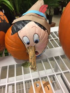 the pumpkins have been painted to look like cartoon characters, and are being held in their mouths