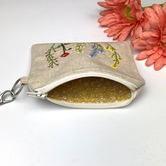 "Linen wristlet pouch is fully lined with 100% Cotton. Perfect for quick errands where you only need your keys, a few cards and cash. Made from a yarn dyed linen blend and fully lined with no raw edges. Wristlet loop is a full 10 inches to easily fit over your hand onto your wrist. You can attach your keys or key fob to the outside as well. Beautifully embroidered with colorful wild flowers and lined with a mustard yellow floral. Perfect gift for Mother's day, co-workers, friends and family. App Bohemian Pouch Wallet For Everyday Use, Everyday Embroidered Wallets, Cheap Floral Embroidered Pouch Bag, Daily Use Pouch Bag With Floral Embroidery, Embroidered Wristlet Keychain, Multicolor Embroidered Floral Pouch Bag, Id Wallet, Credit Card Wallet, Dyed Linen