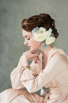 a woman with flowers in her hair sitting down