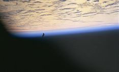 a bird is flying over the earth's horizon