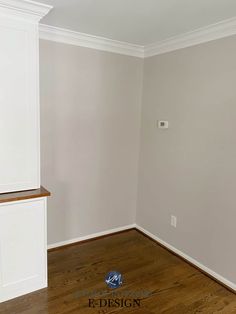 an empty room with white cabinets and wood floors