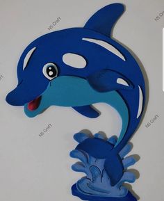 a paper cut out of a blue dolphin with its mouth open and tongue hanging from it's side