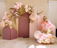 balloons and flowers are on display in front of a pink backdrop with gold trimmings