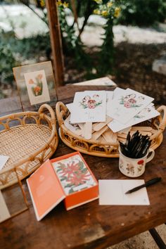 some cards and pens on a wooden table