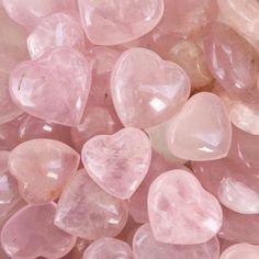 many pink heart shaped stones are scattered together