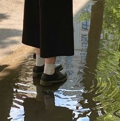 a person standing in the water with their shoes on