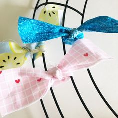 two bows with hearts on them are sitting on a wire rack in front of a wall