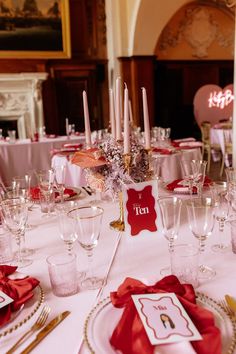 the table is set up for a formal dinner with red napkins and silverware